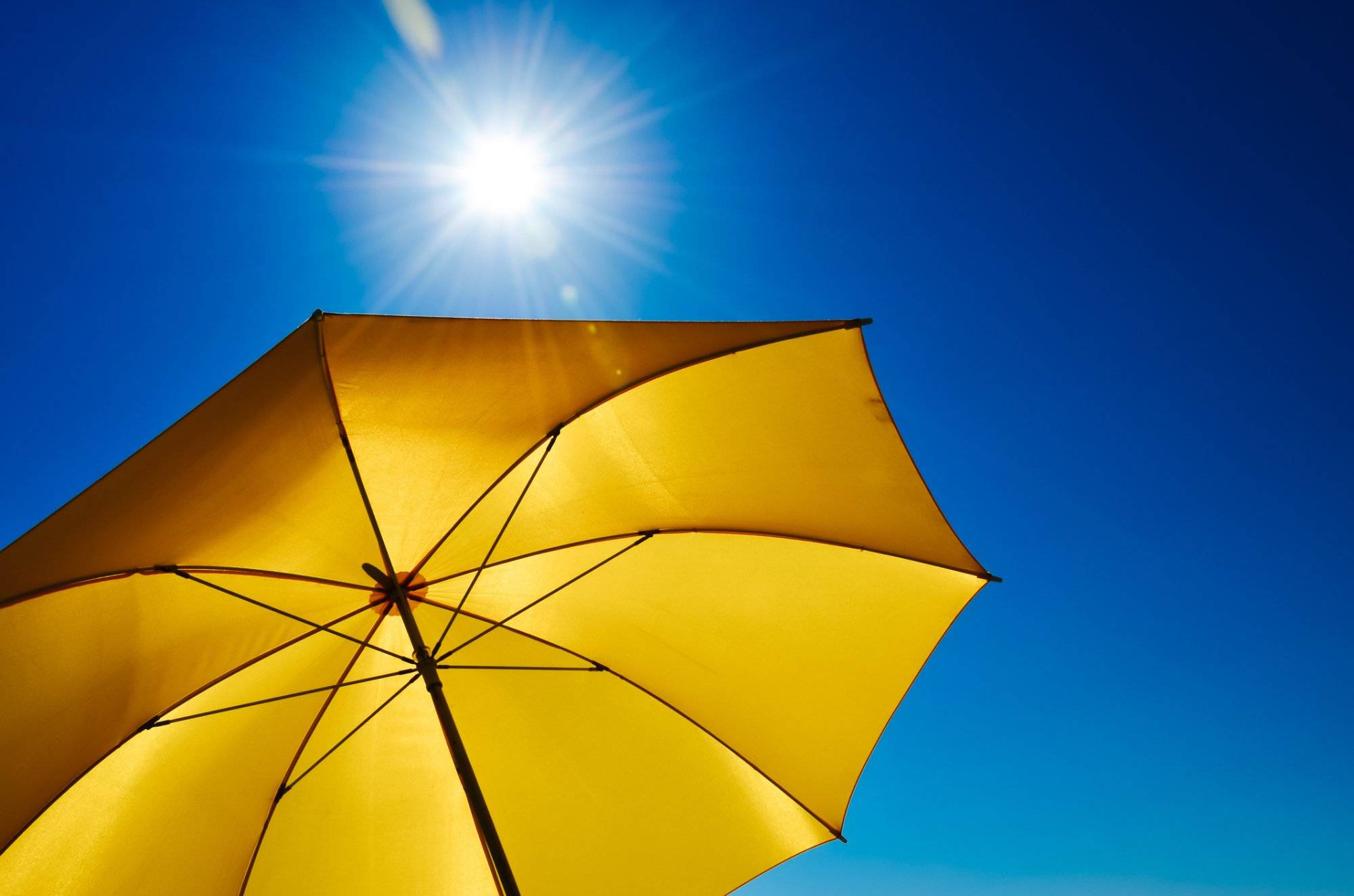 Yellow Umbrella With Bright Sun And Blue Sky